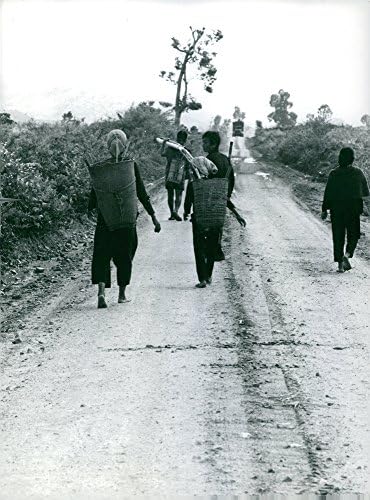Гроздобер фотографија на виетнамски луѓе кои носат корпа и одат по пат.